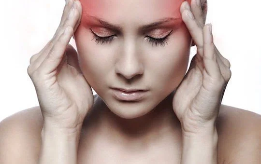 Acupuncture Headache Treatments woman has hands to side of head to show she has headache