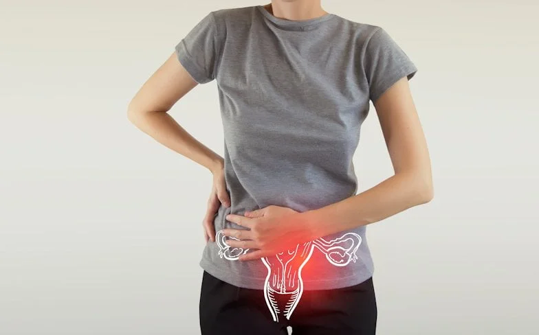 Pelvic Pain - Woman Holding Her Mid-Region Experiencing An Unknown Pain. She is obviously uncomfortable and needs attention. In this case, it would be a physiotherapist who would provide that diagnosis and assist.