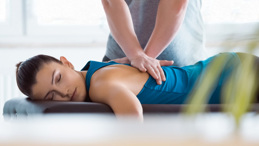 A chiropractor adjusting a female patient to help her meet her goals at the gym