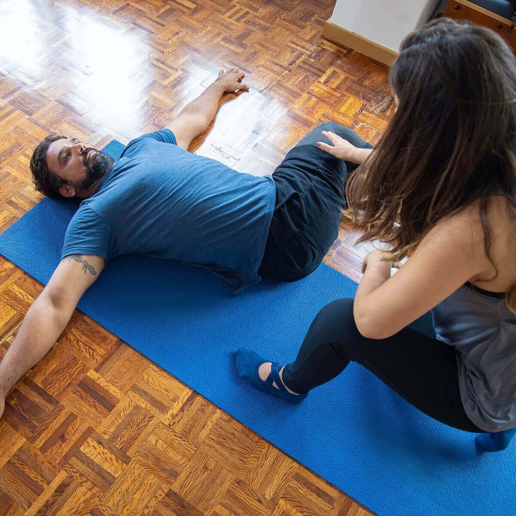 Female physiotherapist helping a male patient with stretching and flexibility